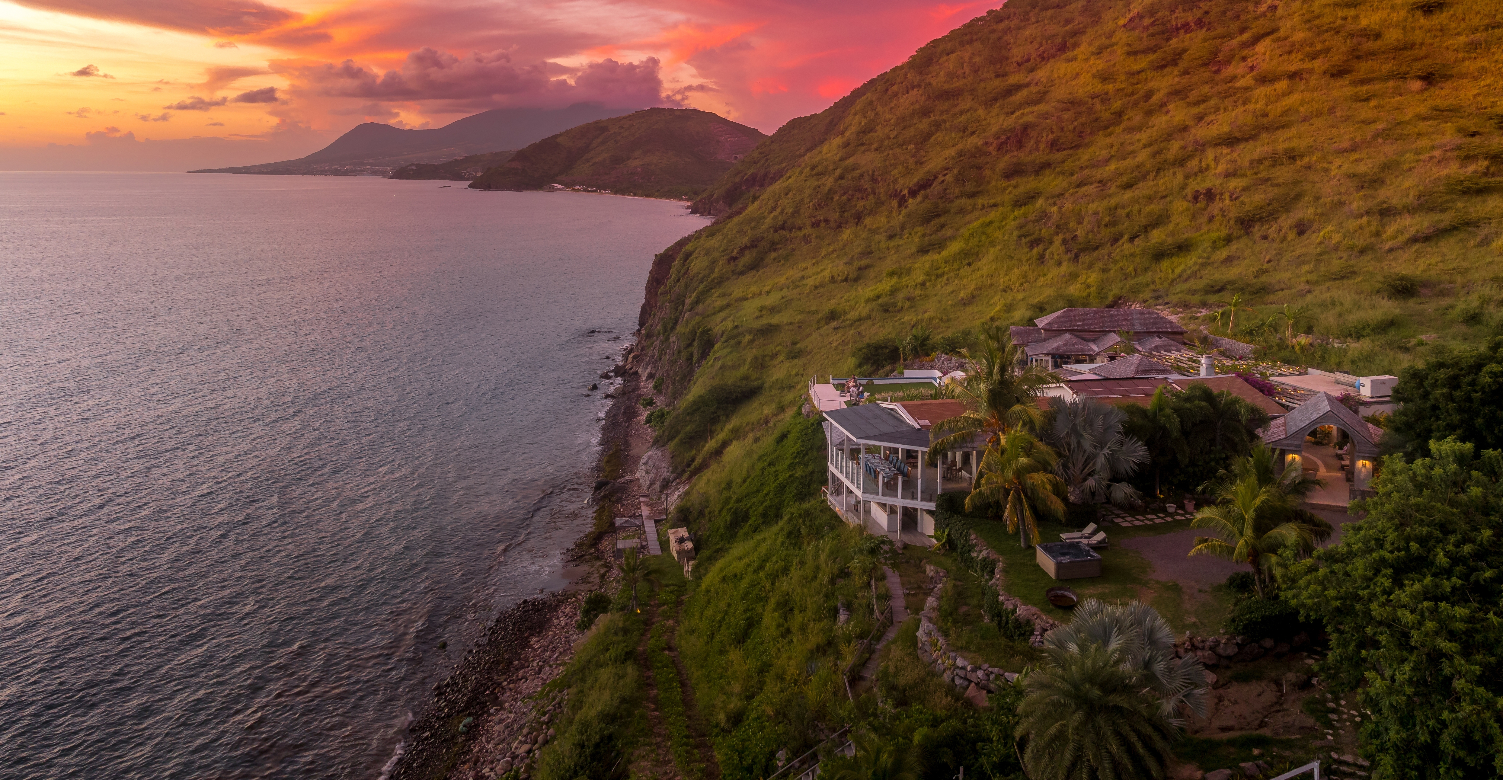 Luxury cliffside villa overlooking the ocean in St. Kitts and Nevis — elite Caribbean coastal real estate at sunset